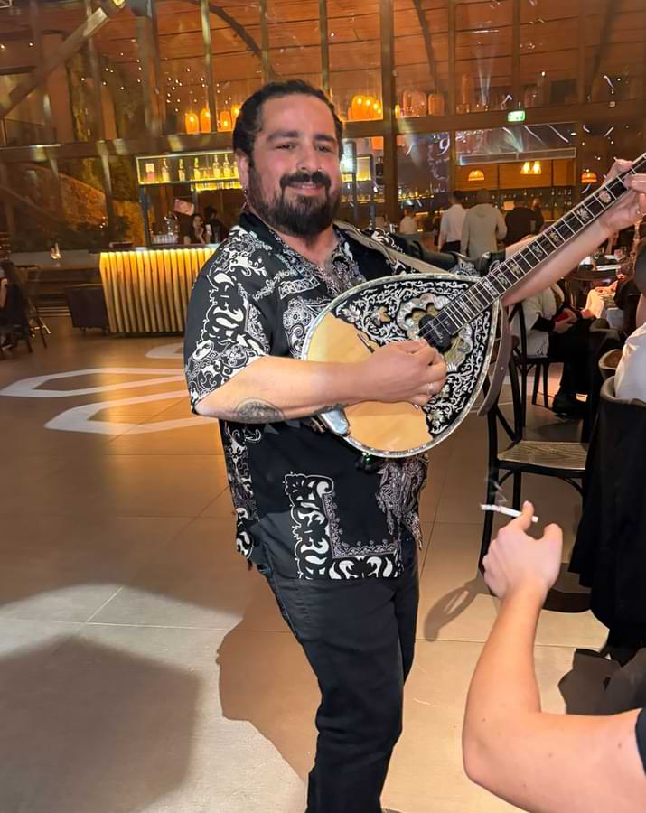 נגן הבוזוקי אוהד מתחיל להרים את האנרגיה ונהנה עם הקהל